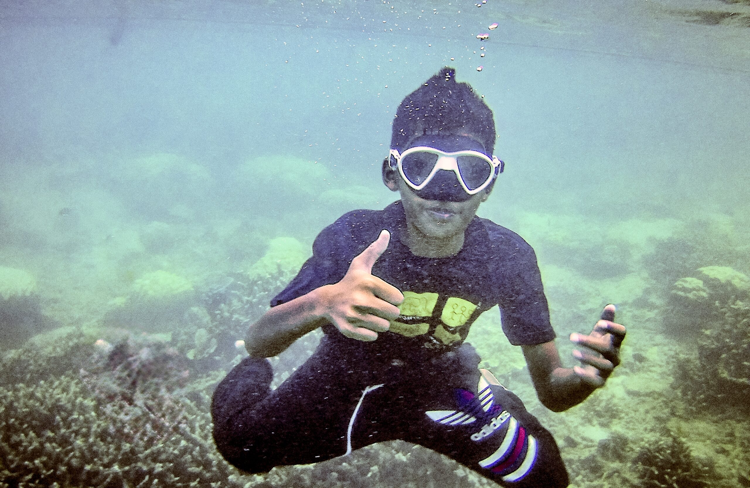 Free diving island boy underwater in Perhentian giving a thumbs up