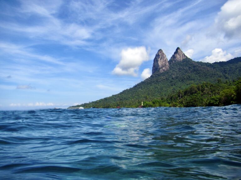 Tioman's twin Dragon Peaks rising over rippling blue water.
